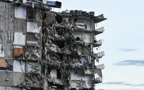 Rubble hangs from a partially collapsed building in Surfside north of Miami Beach