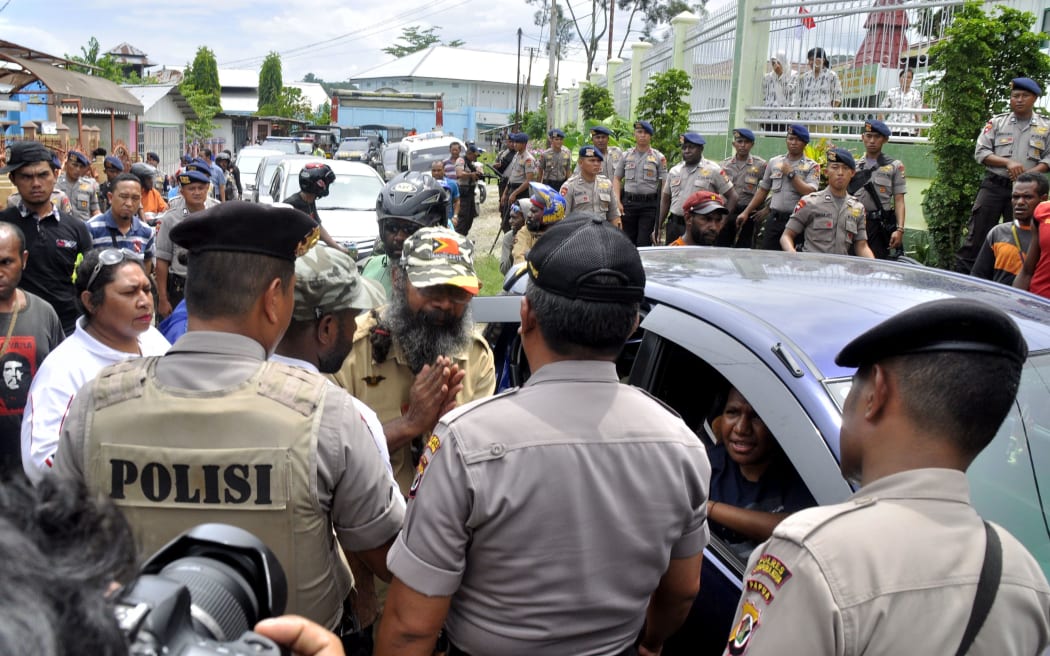 Papuan pro-independence activist Filep Karma (C) asks police for a permit to hold a convoy with his supporters after being released from prison in Abepura, Papua province, on November 19, 2015.