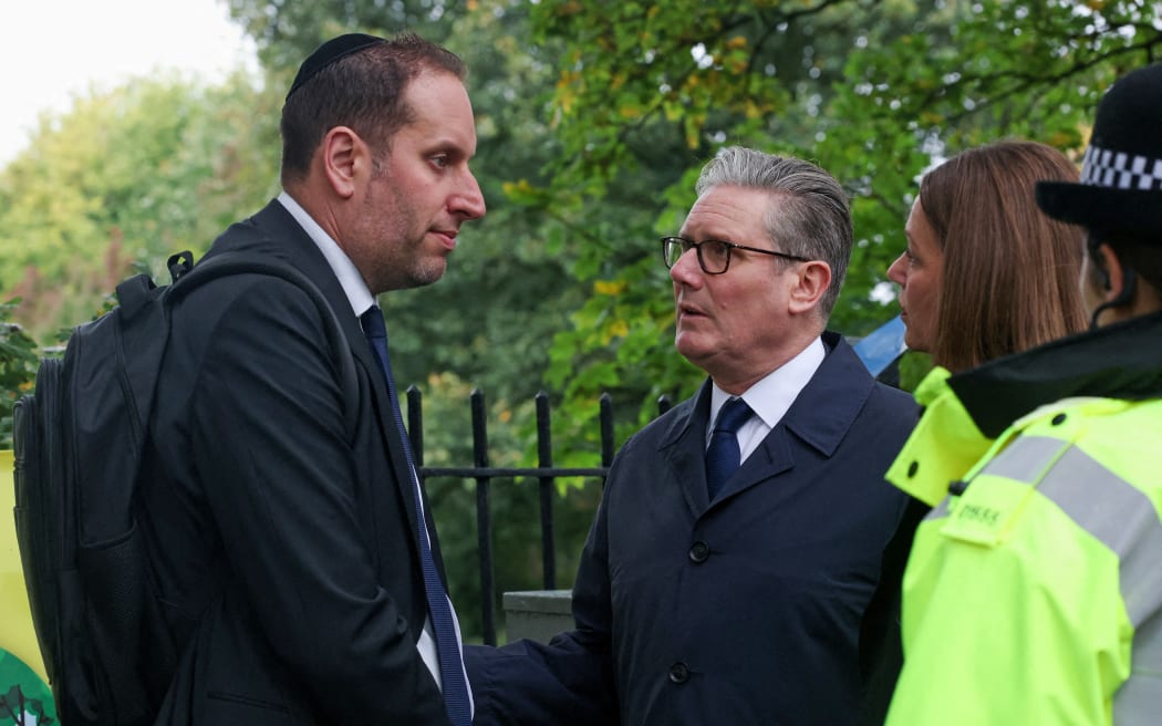 Britain's Prime Minister Keir Starmer and his wife Victoria talk to a member of the local Jewish community as they visit the scene outside Heaton Park Hebrew Congregation synagogue in Crumpsall, north Manchester, on 3 October 3, 2025.