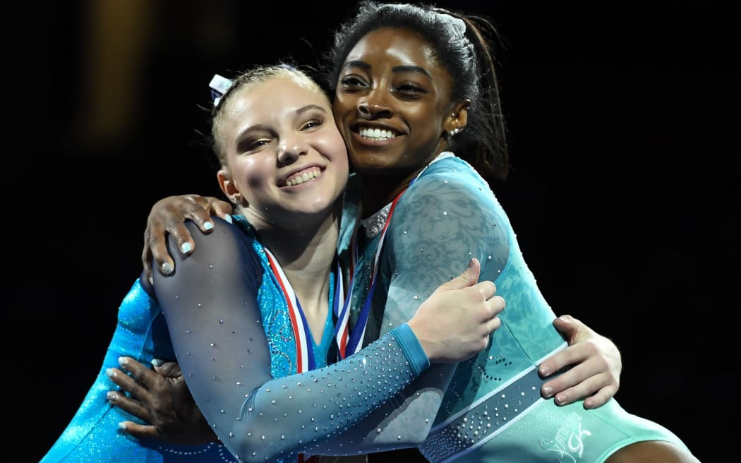 Gymnasts Simone Biles and Jade Carey share a hug on the awards podium at a recent competition in Boston.