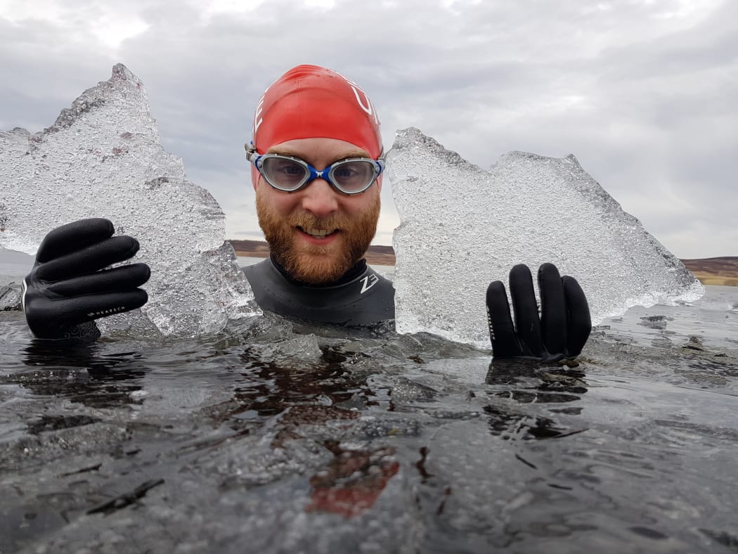 Calum MacLean in water holding ice.