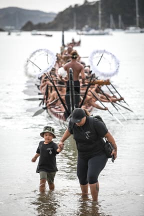 He Kaupapa Waka Waka taua at Waitangi 2020: A future kaihoe rushes in with his mother as Ngatokimatawhaorua comes ashore at Waitangi for the 80th anniversary of its launch in 1940.

The transmission of knowledge and traditions to future generations is an important part of the kaupapa waka and events like these help cement their connection to their identity and culture.