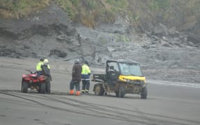 Locals and Landsar personnel at Kiritehere Beach where Thomas Phillips' car was found on Saturday