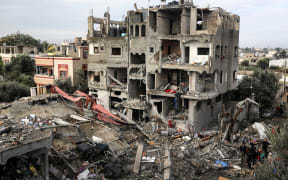 Palestinians are searching through building rubble for survivors following Israeli strikes on the al-Maghazi refugee camp in the central Gaza Strip on 25 December, 2023, amid ongoing battles between Israel and the Palestinian Hamas movement.