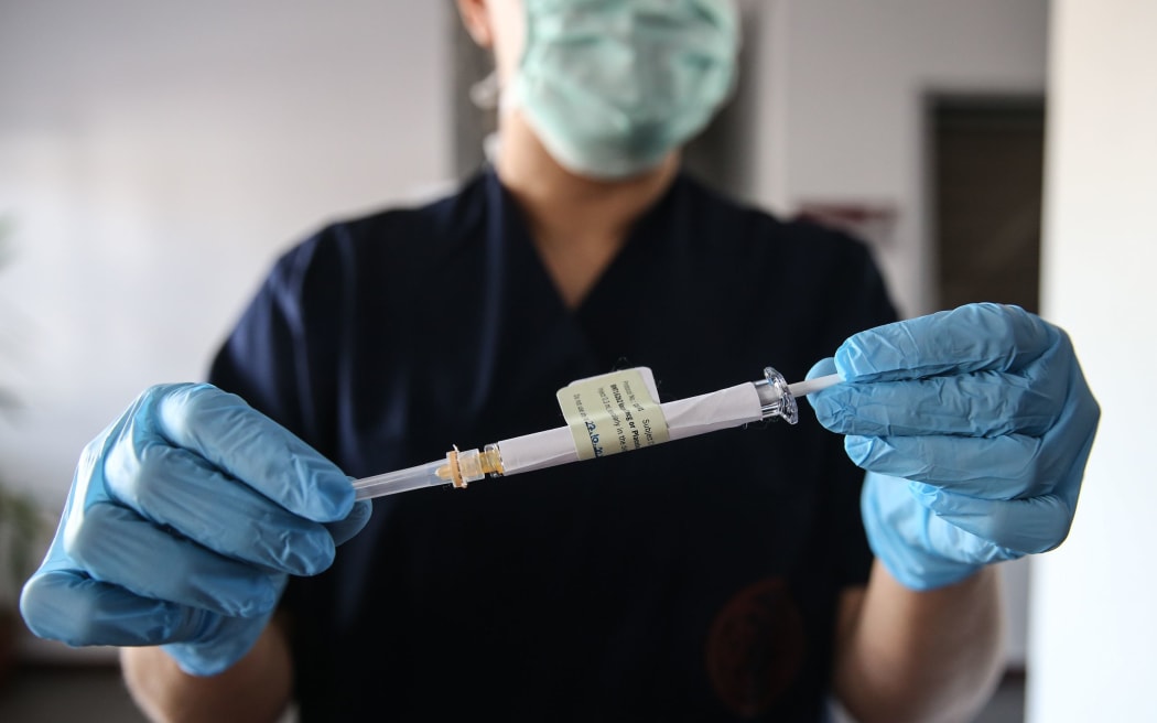 ANKARA, TURKEY - OCTOBER 27: A health care worker holds an injection syringe of the phase 3 vaccine trial, developed against the novel coronavirus (COVID-19) pandemic by the U.S. Pfizer and German BioNTech company, at the Ankara University Ibni Sina Hospital in Ankara, Turkey on October 27, 2020.