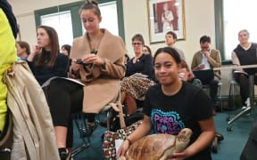 Waiata Rameka-Tupe with the dead New Zealand sea turtle named Tama Kahurangi, which had a stomach full of plastic, at packed Auckland Council meeting.