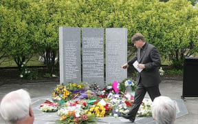 Rev. Dr Richard Waugh, during the Mt. Erebus 25th anniversary service at Auckland’s Waikumete Cemetery. He is sprinkling water, brought from Mt Erebus, over flowers in front of the memorial to 44 victims, November 2004.  (Air New Zealand)