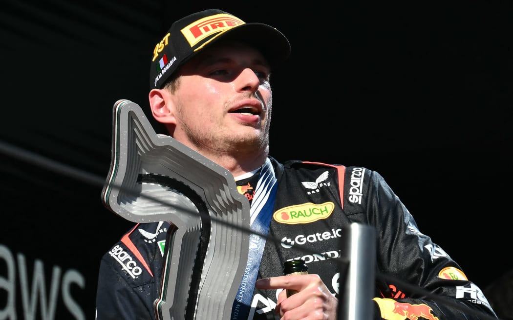 Red Bull Racing's Dutch driver Max Verstappen celebrates with the trophy on the podium after winning the 2025 Emilia Romagna Formula One Grand Prix at the Imola autodrome in Imola, on May 18, 2025.