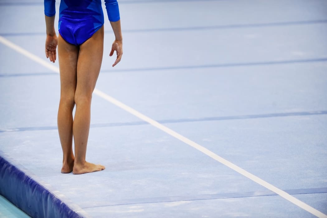 Feet of gymnast are seen on the floor exercise before gymnastics competition