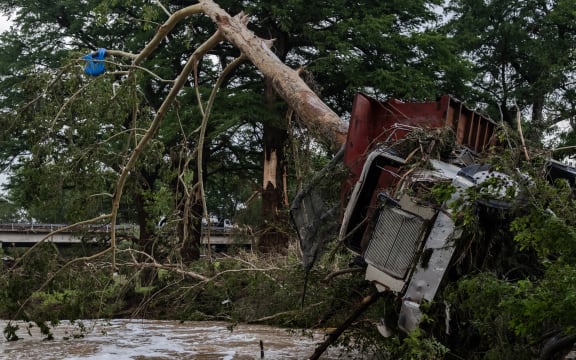 CENTER POINT, TEXAS - JULY 05: A large truck is impaled onto a tree after flash flooding on the bank Guadalupe River on July 5, 2025 in Center Point, Texas. Heavy rainfall caused flooding along the Guadalupe River in central Texas with multiple fatalities reported.   Jim Vondruska/Getty Images/AFP (Photo by Jim Vondruska / GETTY IMAGES NORTH AMERICA / Getty Images via AFP)