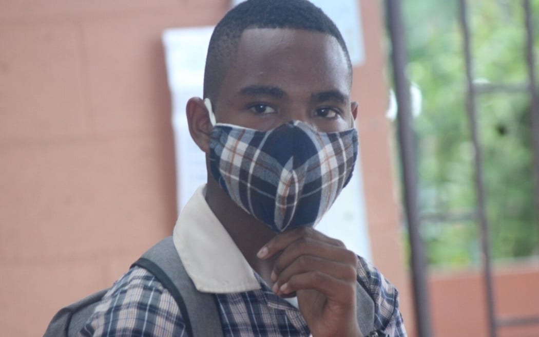A Kopkop college student wearing a mask.