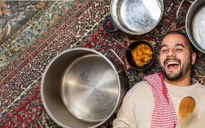 Image of Joshua Hinton surrounded by pots, pans and curry.