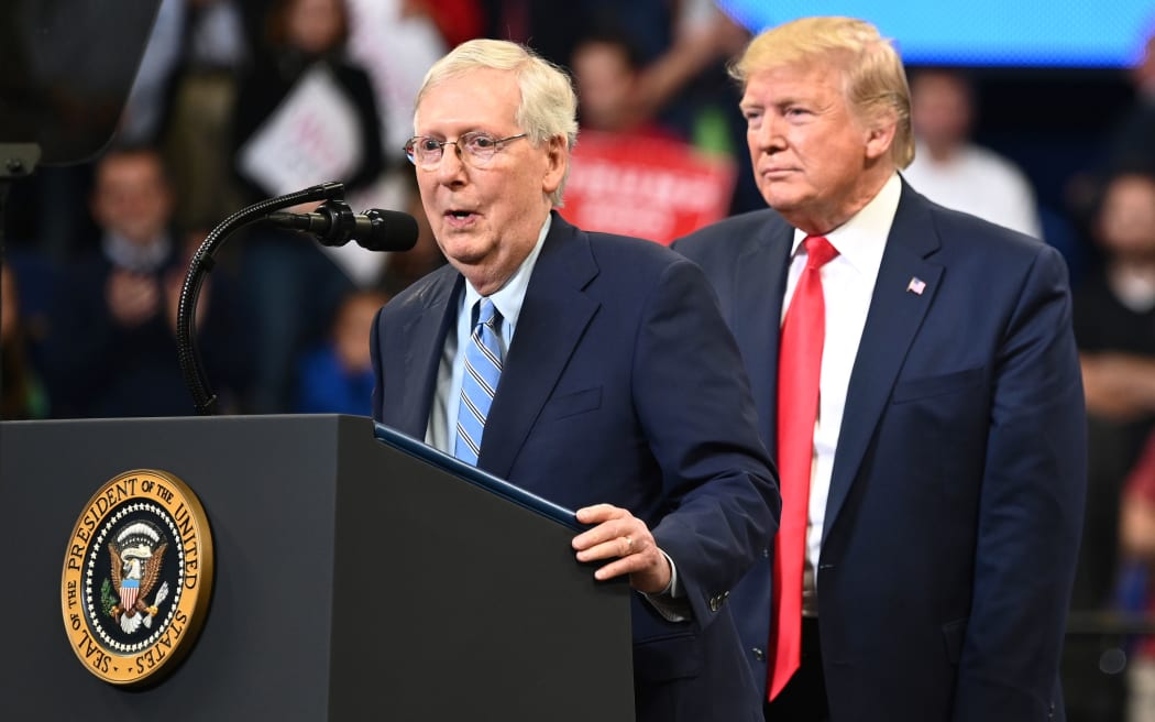 US President Donald Trump (R) looks on as Senate Majority Leader Mitch McConnell, R-KY, speaks during a rally at Rupp Arena in Lexington, Kentucky on November 4, 2019.