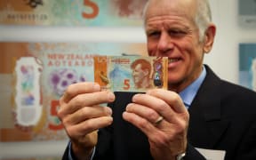 Peter Hillary holding the $5 note with his father Sir Edmond Hillary on it.