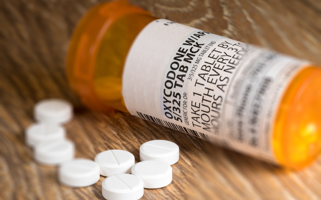 Tiltshift effect of prescription bottle for Oxycodone tablets and pills on wooden table for opioid epidemic illustration