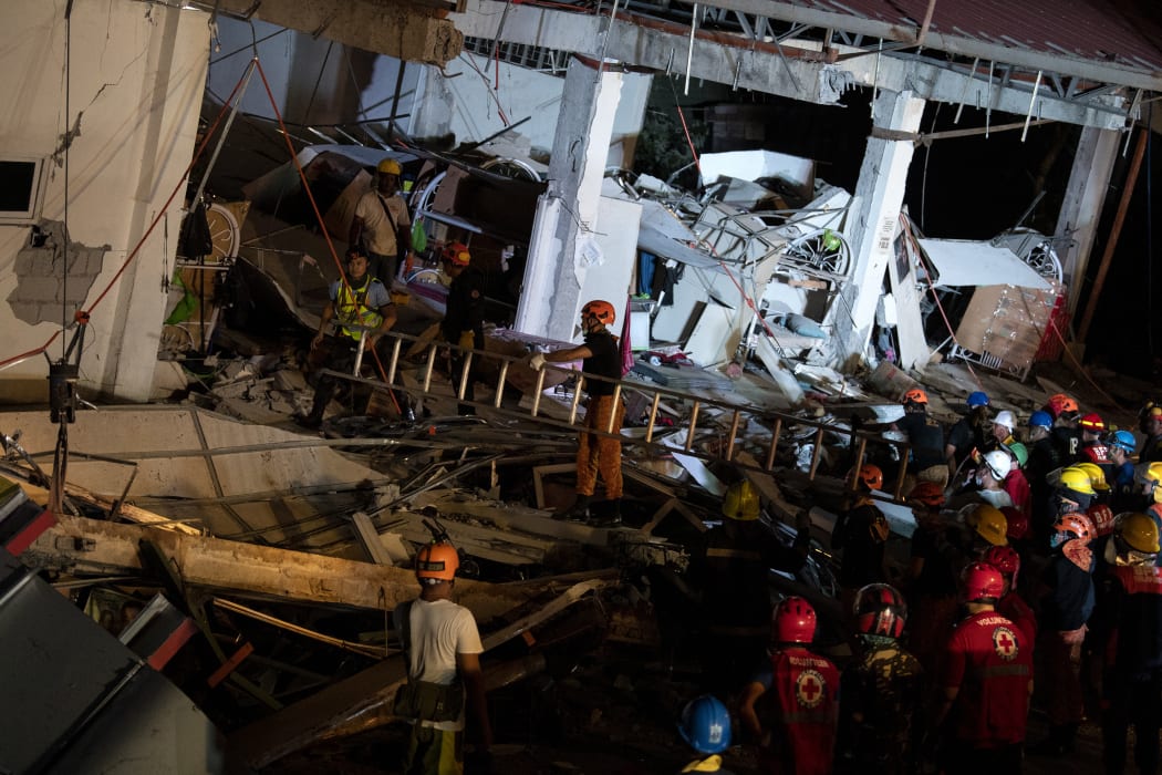 Rescue workers search for survivors in a collapsed Chuzon Super Market in Porac, Pampanga, after a powerful earthquake hit northern Philippines on April 22, 2019.