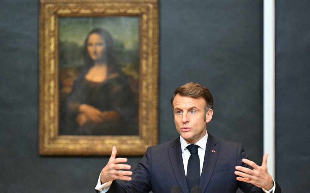 France's President Emmanuel Macron gives a speech in front of the painting "La Joconde" (the Mona Lisa) by Italian artist Leonardo Da Vinci at the Louvre Museum in Paris on 28 January 2025. Leonardo da Vinci's Mona Lisa will be moved to a new special space in the Louvre, accessible independently from the rest of the museum and for this reason provided with its own access ticket, Emmanuel Macron announced on January 28, 2025. (Photo by Bertrand GUAY / POOL / AFP) / RESTRICTED TO EDITORIAL USE - MANDATORY MENTION OF THE ARTIST UPON PUBLICATION - TO ILLUSTRATE THE EVENT AS SPECIFIED IN THE CAPTION