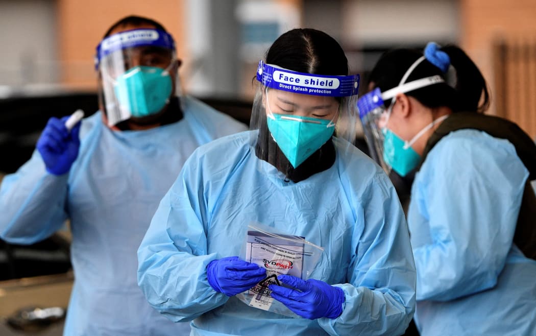 Health workers collect swab samples from residents at a Covid-19 drive-through testing clinic in Sydney's Fairfield suburb on July 14, 2021.