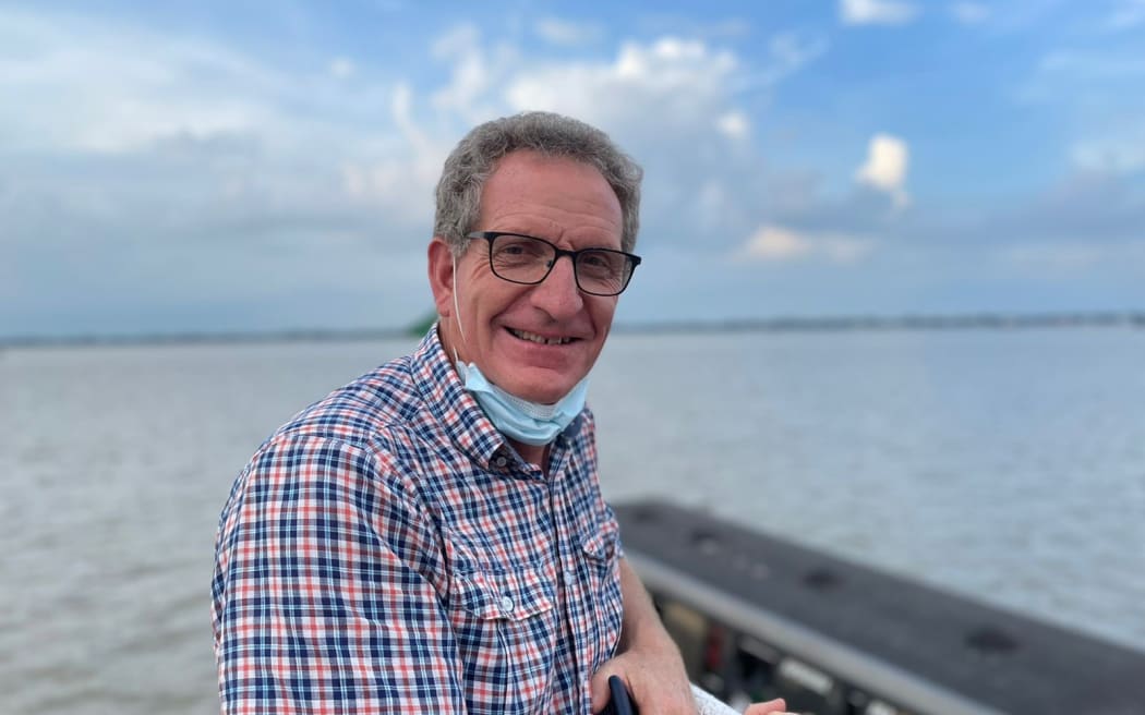 Owen Calvert sits in front of a lake in Bangladesh