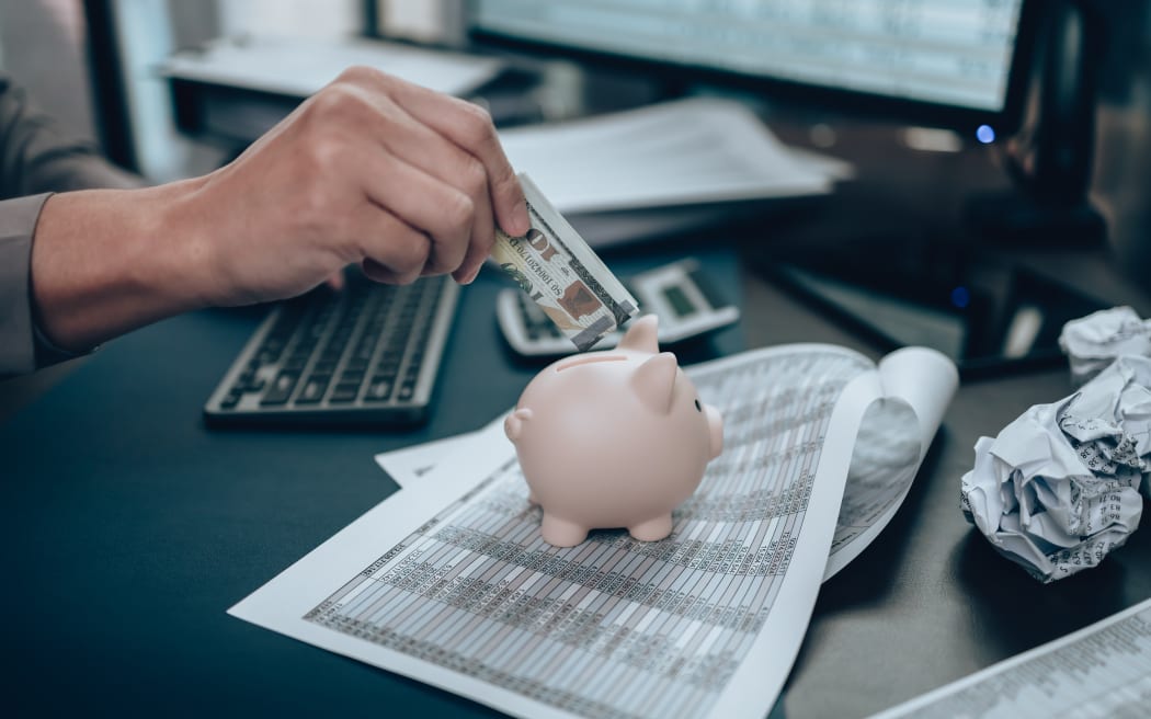 Investors hand putting money into piggy bank. Business saving money and financial concept.