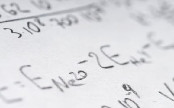 Maths book open with math problems written down