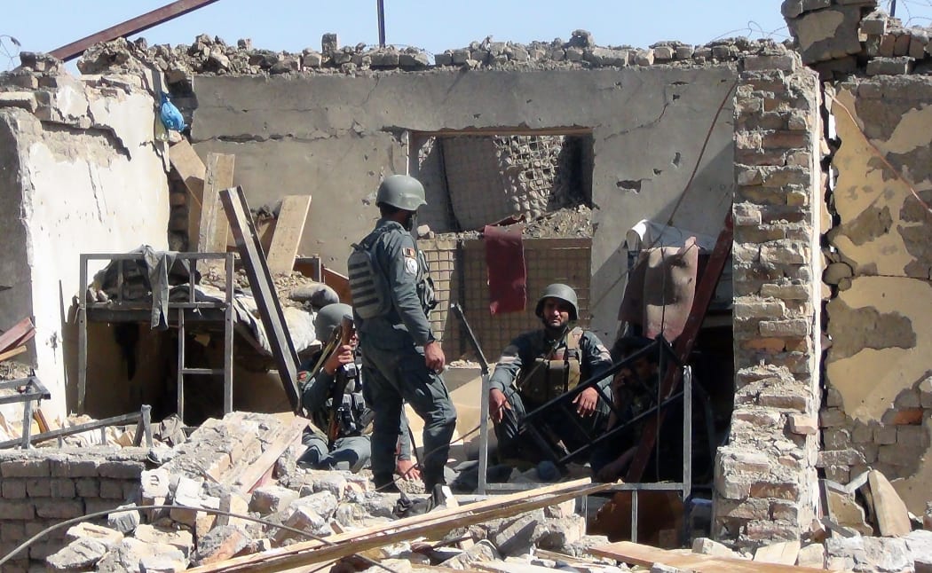 Afghan policemen at the site of the suicide bombing attack.