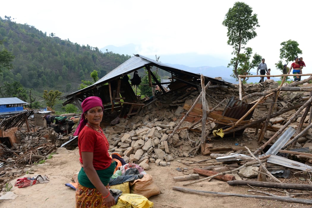A villager stands near a damaged house at Arupokhari in Gorkha.