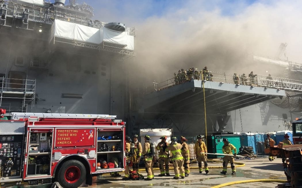 This handout photo released by the US Navy shows sailors and Federal Fire San Diego firefighters combatting a fire aboard the amphibious assault ship USS Bonhomme Richard at Naval Base San Diego, July 12, 2020.