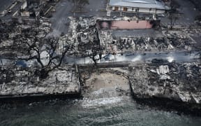 An aerial image taken on August 10, 2023 shows destroyed homes and buildings on the waterfront burned to the ground in Lahaina in the aftermath of wildfires in western Maui, Hawaii. At least 36 people have died after a fast-moving wildfire turned Lahaina to ashes, officials said August 9, 2023 as visitors asked to leave the island of Maui found themselves stranded at the airport. The fires began burning early August 8, scorching thousands of acres and putting homes, businesses and 35,000 lives at risk on Maui, the Hawaii Emergency Management Agency said in a statement. (Photo by Patrick T. Fallon / AFP)