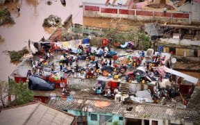 People gather on the roof of a house submerged by floods in Buzi, central Mozambique.