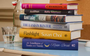 Six colourful books arranged in a stack.