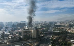 This aerial photo shows smoke billowing from a building in Damascus on 8 December 2024, after rebels took the city.