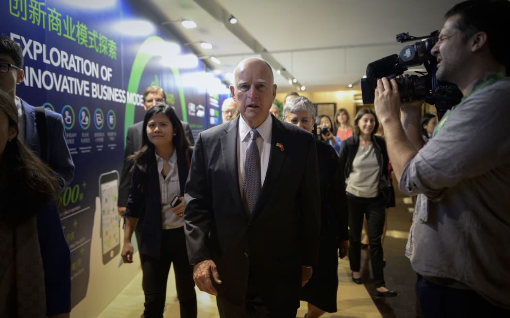 California Governor Jerry Brown (C) arrives to attend a meeting ahead of the Clean Energy Ministerial international forum in Beijing on June 6, 201