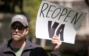 Arlen Penfield, of Goochland, Virginia protests against stay-at-home orders related to the coronavirus pandemic at Capitol Square in Richmond, Virginia on April 16, 2020.