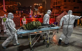 There is a "strong association" between the early outbreak and the sale of live animals in a market in Wuhan, scientists say. Medics arrive with a patient at the Wuhan Red Cross Hospital, 25 January 2020.