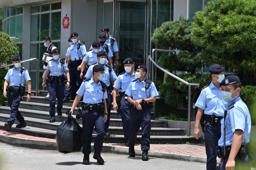 Police officers leave the Apple Daily newspaper offices in Hong Kong on June 17, 2021.
