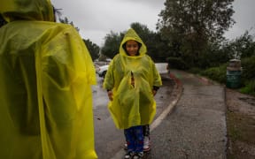 A family walks at Elysian Park in the rain on December 24, 2025 in Los Angeles, California. A major winter storm rolled into California on December 23, forcing hundreds of evacuations in burn areas while threatening flooding and travel delays through Christmas for much of the state, officials said.
A "strong atmospheric river brings heavy rain, snow, and wind to California through Friday," the National Weather Service said in a statement on December 23, warning anyone in northern, central and southern parts of the state to "exercise extreme caution." (Photo by Apu GOMES / AFP)