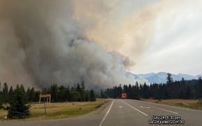 In this July 24, 2024, image obtained from the Jasper National Park in Canada, smoke rises from a wildfire burning in the park. The "out of control" wildfire has devoured up to half of the main town in western Canada's popular Jasper National Park, authorities said July 25, with 400 foreign firefighters called in to help battle the blaze. (Photo by Handout / Jasper National Park / AFP)