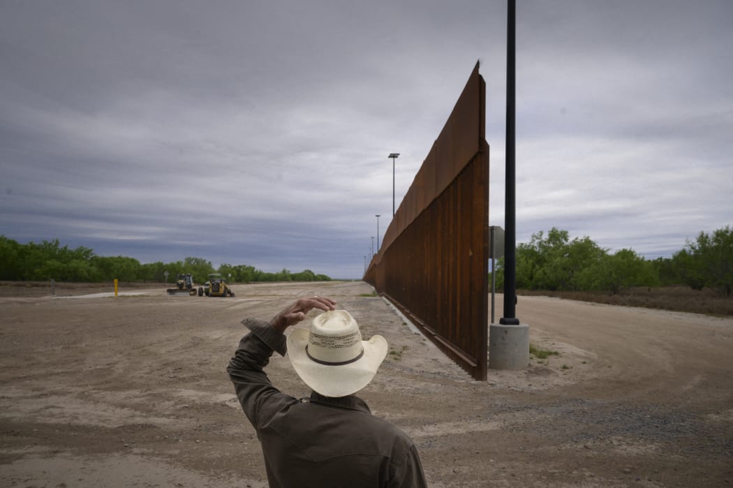 In this file photo taken on March 28, 2021, ranch owner Tony Sandoval (67) stands before a portion of the unfinished border wall that former US president Donald Trump tried to build, near the southern Texas border city of Roma.