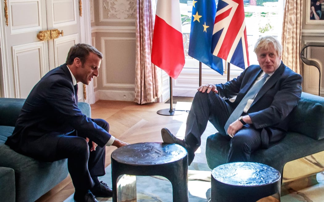 Britain's Prime Minister Boris Johnson (R) places his foot on the table during a meeting with French President Emmanuel Macron (L) at the Elysee Palace in Paris, France, on August 22, 2019.
