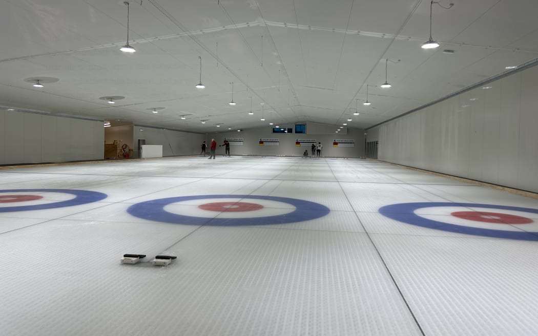 Picture shows a curling rink that's nearly empty.