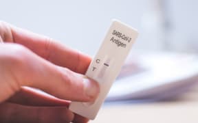 Close up of fingers holding express antigen covid test, negative result