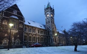 a blanket of snow covers the grey stone buildings of Otago University