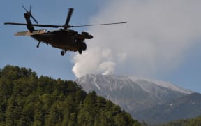A military helicopter leaves a temporary landing site for a rescue mission on Japan's Mount Ontake.