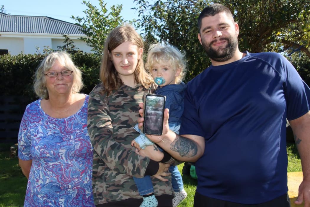 Isaac McCallum has an app on his cellphone so if he wanders off in a semi-conscious state before a seizure, family (from left) his mother Teresa and partner Abbie Willoughby, holding son Harrison, will be able to call police who can track his location.