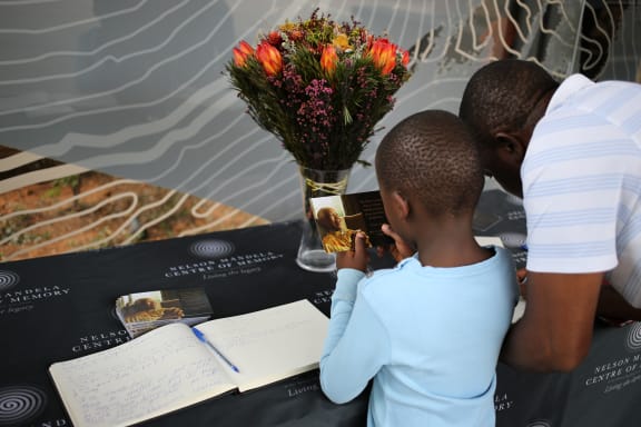 Messages are left in a condolence book in Johannesburg on Saturday.