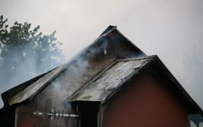 The back of St John's Presbyterian Church as fire takes hold. The church was gutted by the blaze.