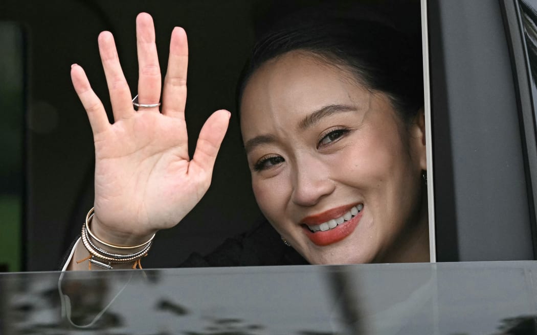 Thailand's sacked prime minister Paetongtarn Shinawatra waves from a car as she leaves Government House after her dismissal by the Constitutional Court in Bangkok on 29 August, 2025.