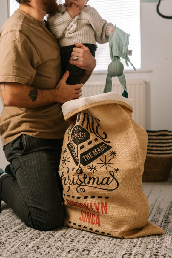 Father and young child with Christmas sack