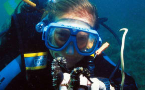 Amanda Vincent underwater with two seahorses.